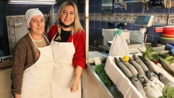 İki kadın çiğin omuza balık satarak ekmeklerini çıkarıyor